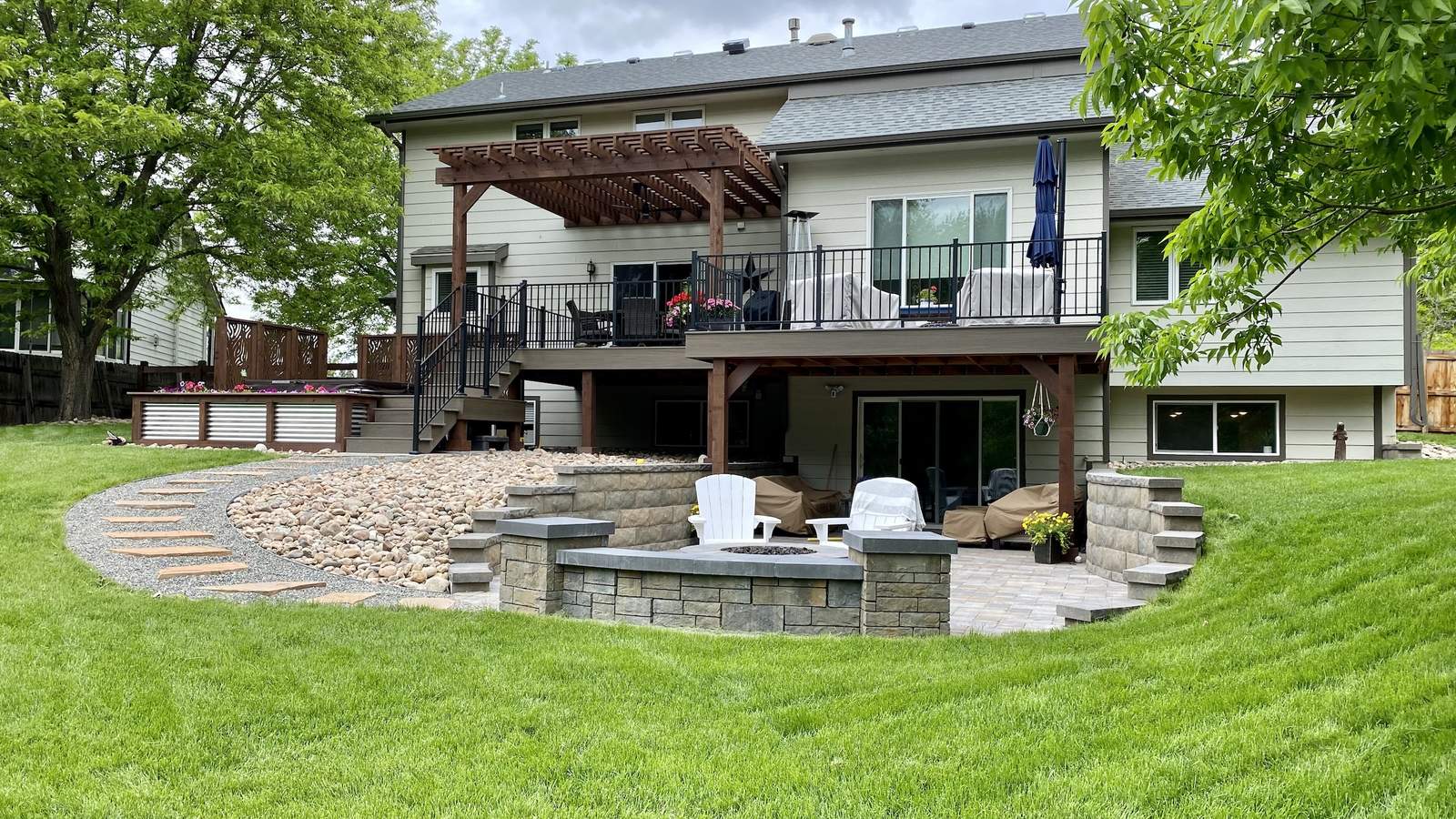 Tiered backyard renovation with two-story deck, cedar pergola, and stone fire pit patio